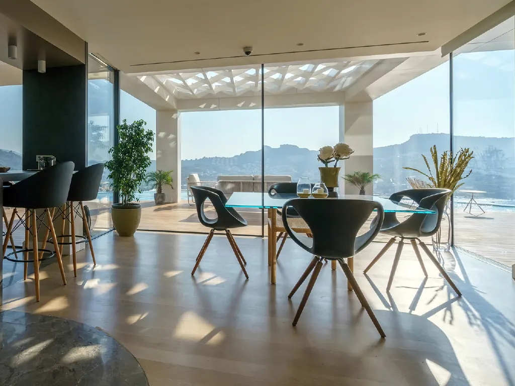 Comedor con un cerramiento minimalista de aluminio y vistas al mar