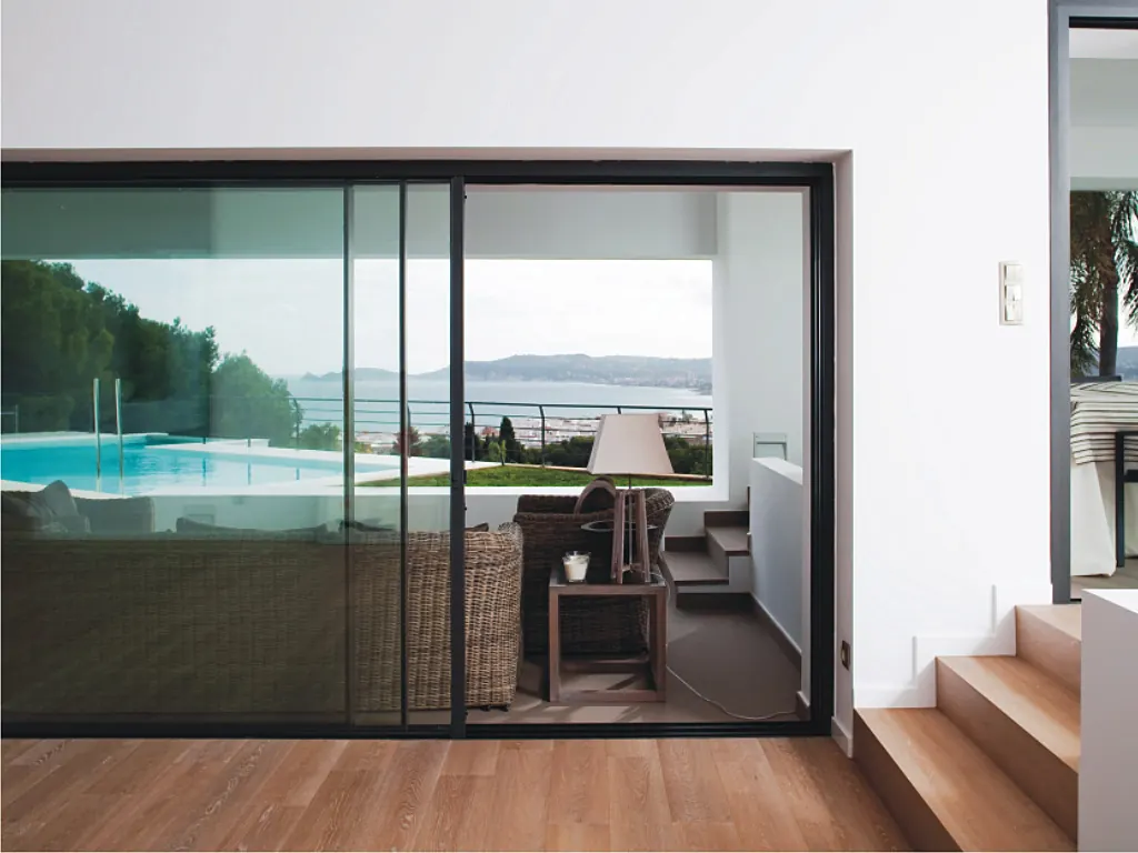 Corredera de aluminio abierta a una terraza con piscina