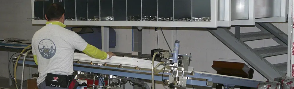 Operario con camiseta de Koryak PVC colocando un perfil en una máquina